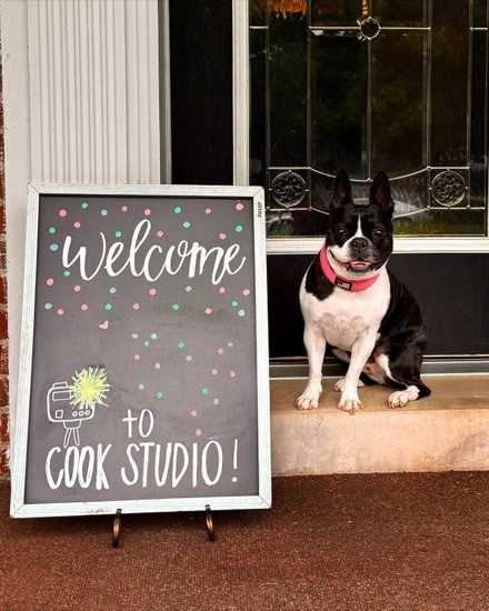 Pippi the Boston Terrier beside the Cook Studio welcome sign